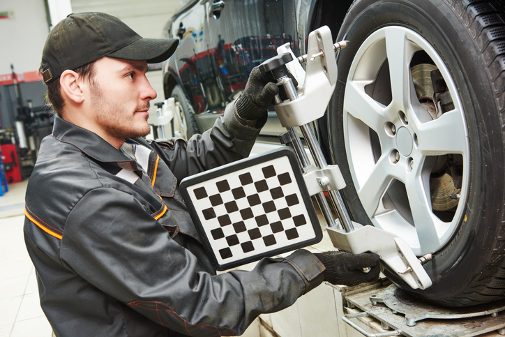 Mécanicien-réparateur en automobile qui vérifie l’alignement des roues.