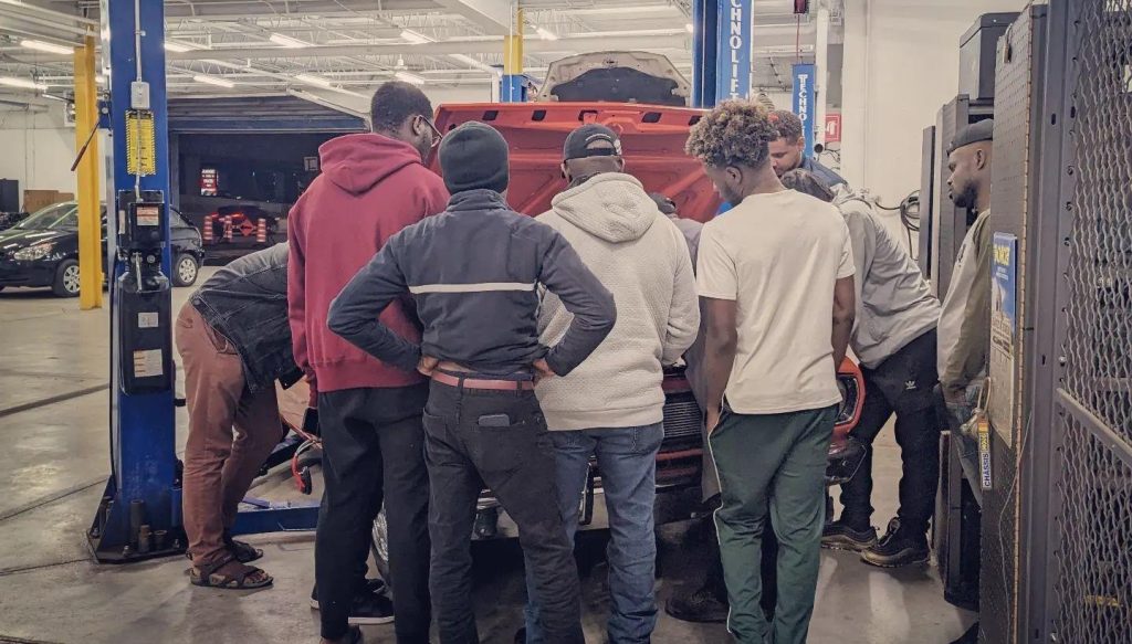 Étudiants en formation mécanique automobile en atelier pratique à L'École de L'Automobile