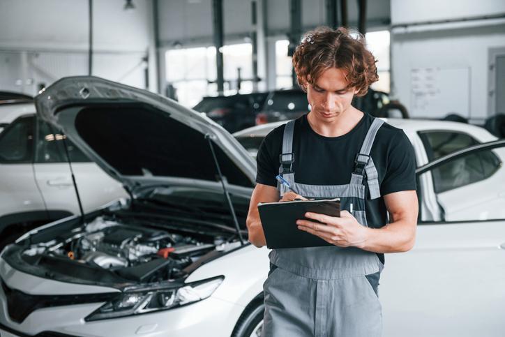 Étudiants en formation de mécanique automobile hybride et électrique en cours pratique