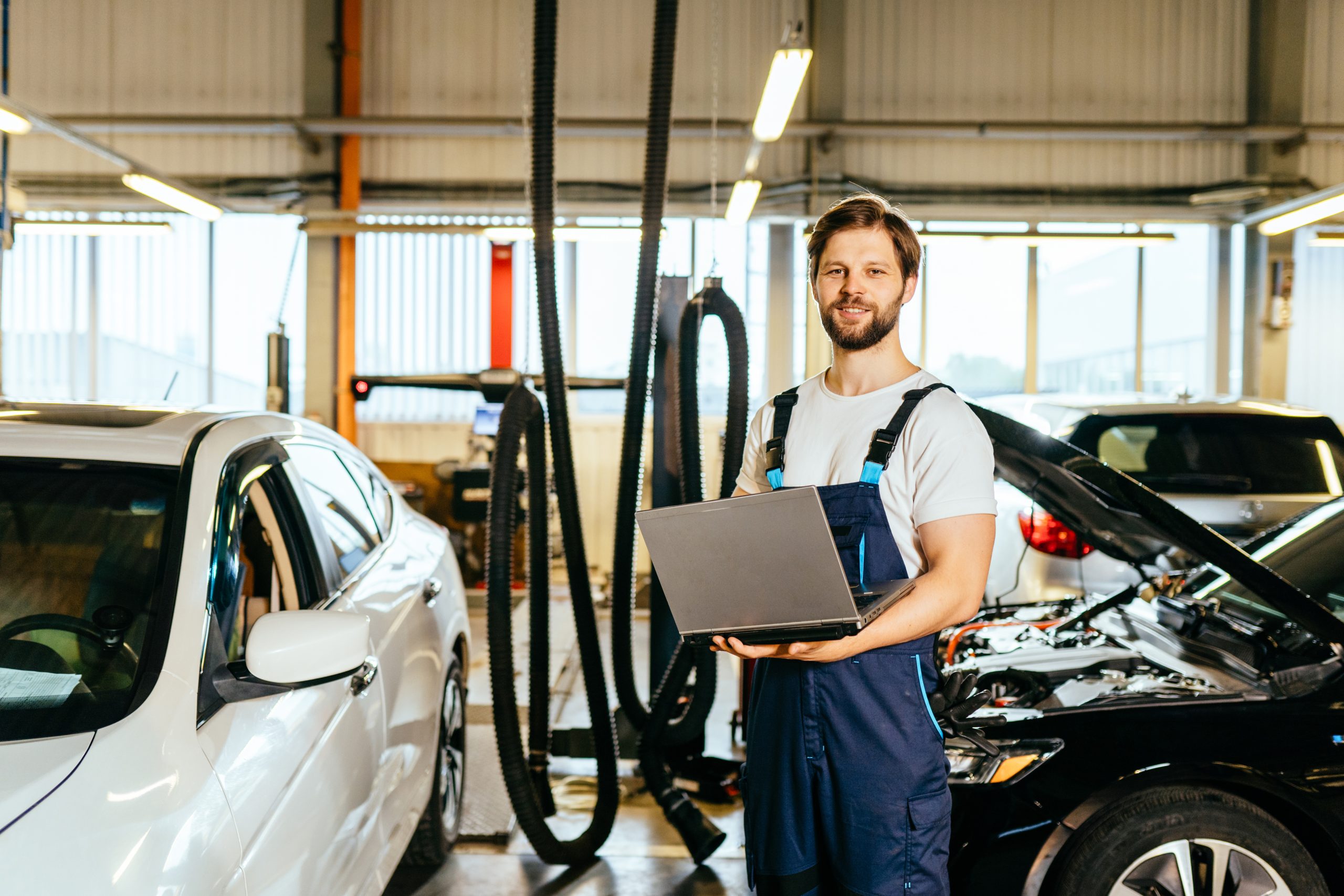 Étudiant en formation mécanique automobile qui travaille dans l’atelier avec un ordinateur