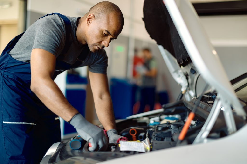 Étudiants en formation mécanique automobile en cours pratique qui répare un véhicule