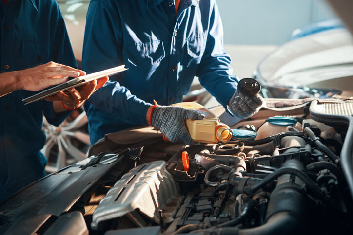 Étudiant en formation mécanique automobile qui travaille dans l’atelier sur une fuite de liquide