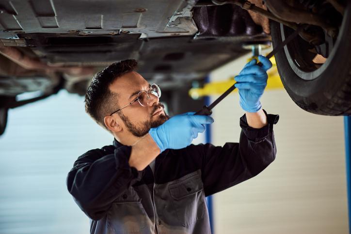 Étudiants en formation mécanique automobile en cours pratique réparant un véhicule