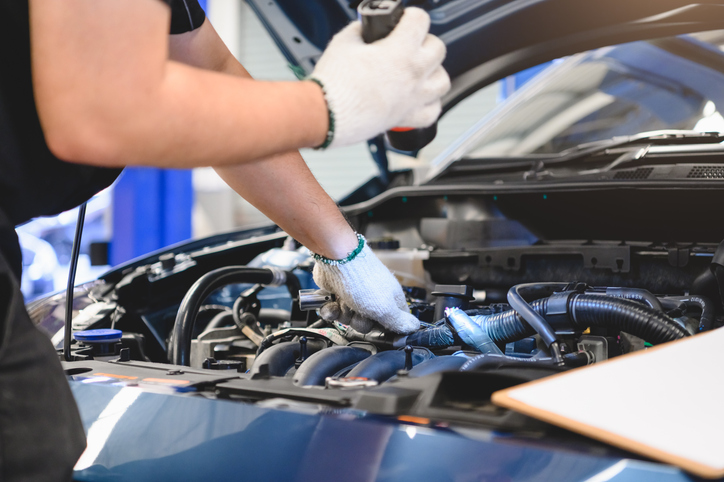 Technicien qui essaye de déterminer les causes d'une auto qui cale au ralenti.