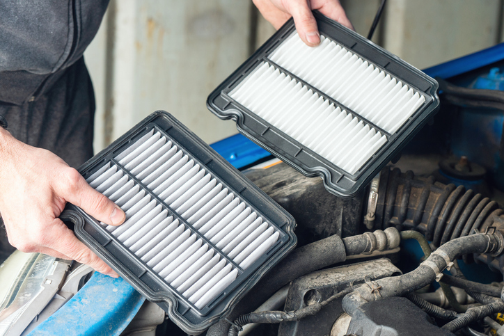 Mécanicien inspectant un filtre à air obstrué dans un garage