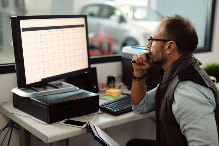 Un conseiller planifiant les réparations d’un véhicule à l’aide d’un logiciel professionnel.