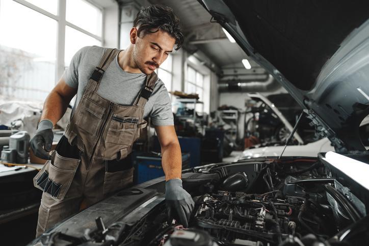 Technicien metant à profit ses compétences en mécanique automobile pour un diagnostic.