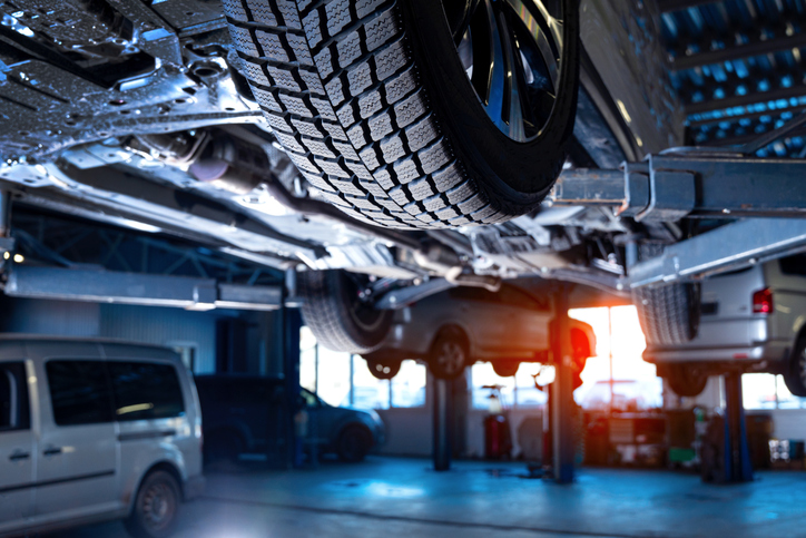 Photo d’un atelier de réparation automobile montrant des véhicules électriques en maintenance.