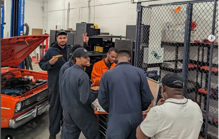 Groupe d’élèves dans le garage de L’École de L’Automobile.