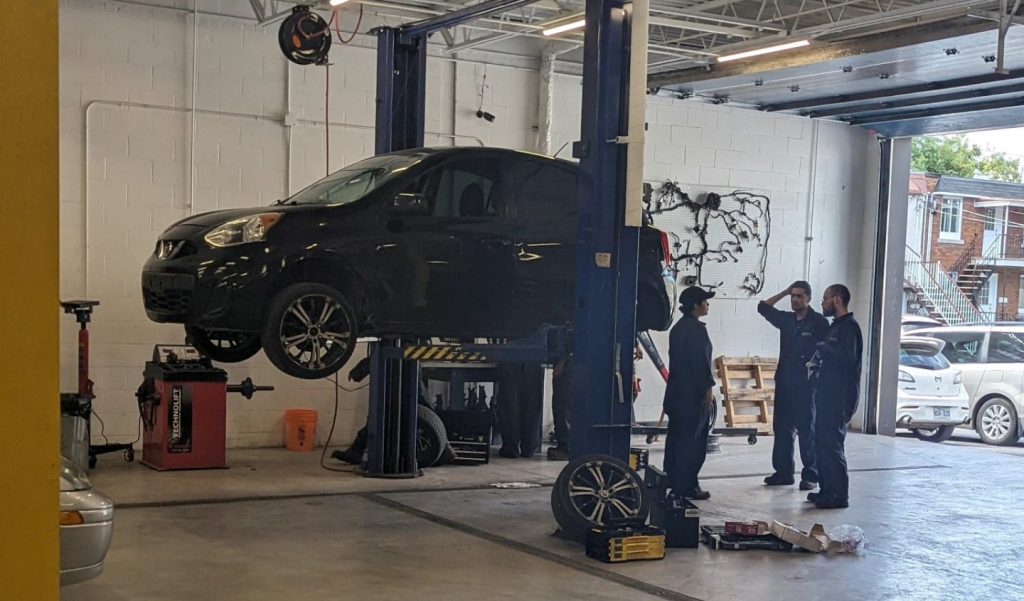 Étudiants discutant dans l’atelier de pratique de L’École de L'Automobile.