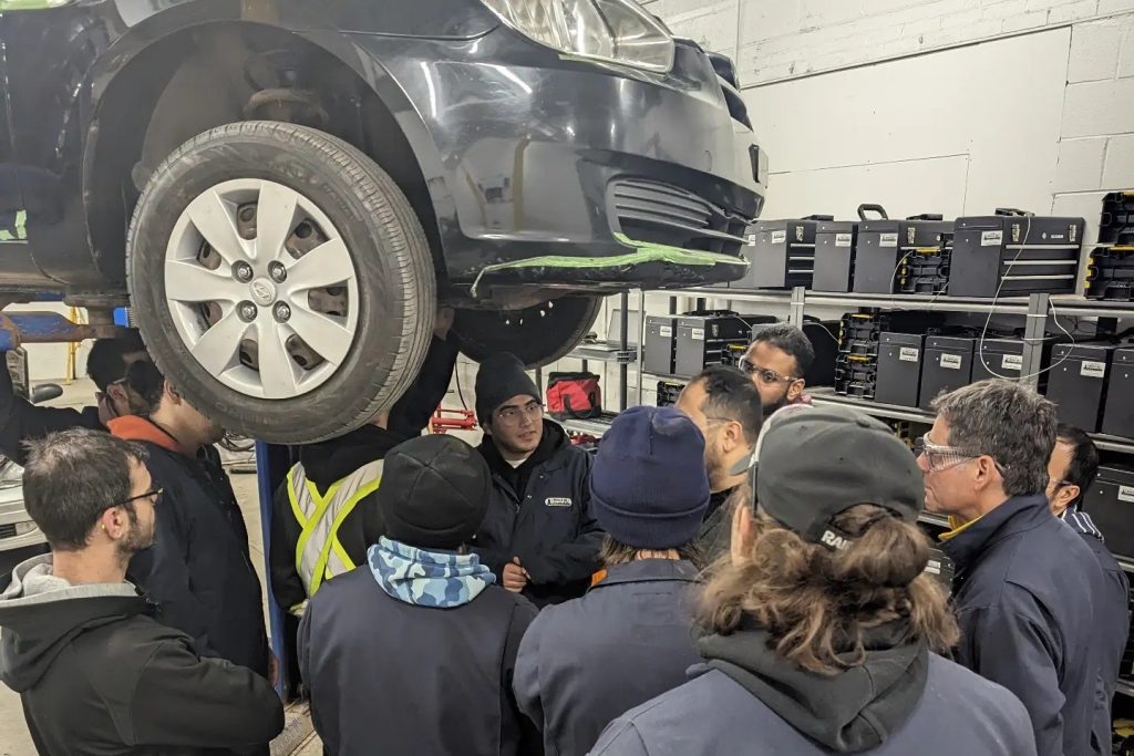 Étudiants participant au tournoi de changement de pneus à L’École de L’Automobile