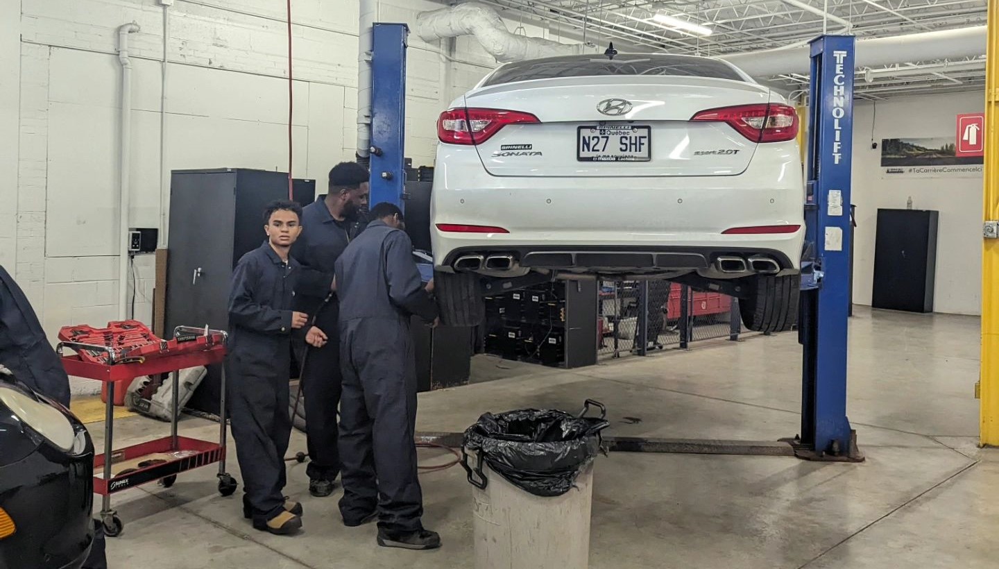 Étudiants en mécanique dans le garage de L’École de L’Automobile