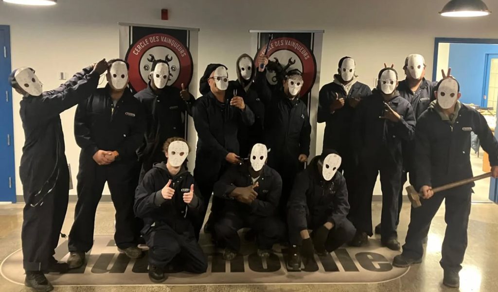 Étudiants en mécanique automobile portant un masque lors de l’Halloween.