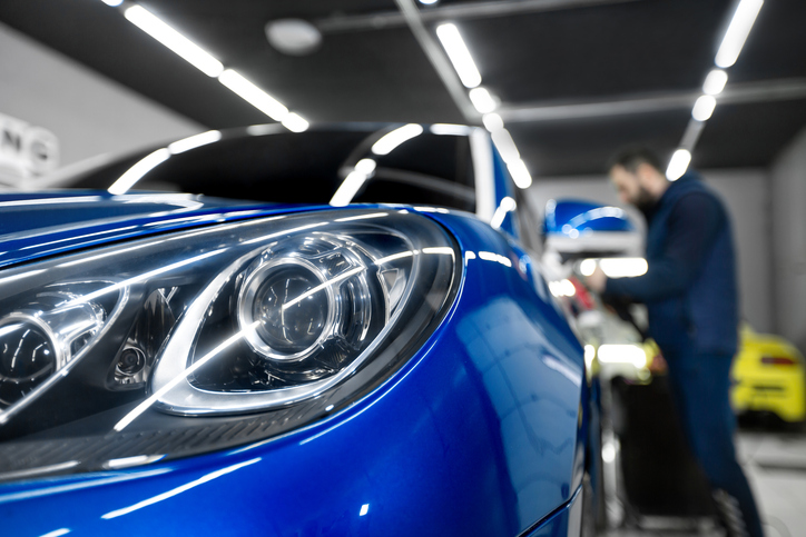 Atelier d'une école spécialisée en esthétique automobile avec des étudiants en formation.