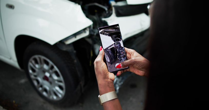 Un expert en dommages automobiles prenant des photos des dommages.